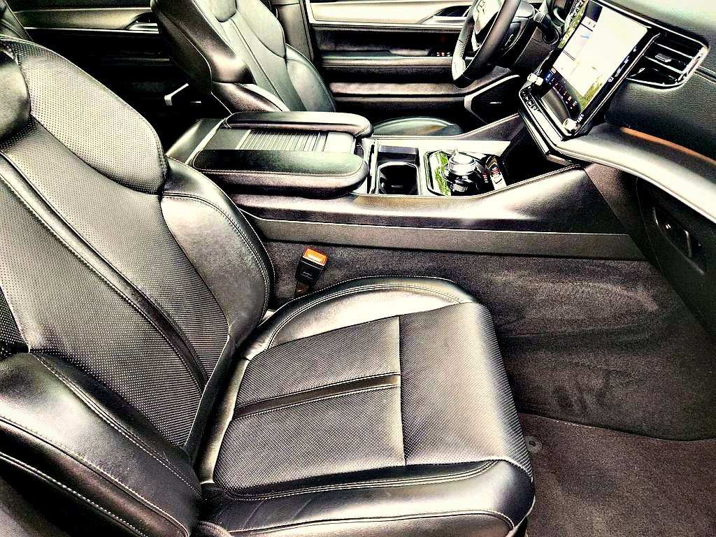 Front cabin with black leather seats and a large touchscreen